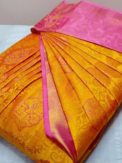 A bright yellow and pink saree, perfect for a festive look. The pleats are crisp and ready, saving you time and effort.
