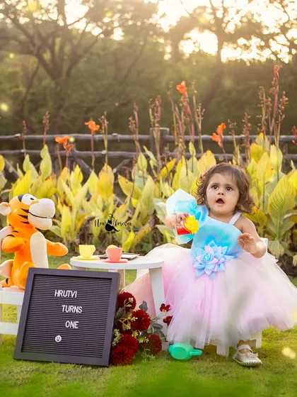 A lovely outdoor tea party to celebrate Hrutvi turning one. First birthday shoots can be customized to any theme, from a fun picnic to a whimsical party like this one, set against a beautiful natural backdrop.
