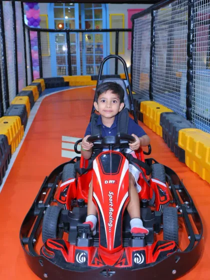 A young boy in a blue shirt looks ready for a fun and speedy adventure on our go-kart track.
