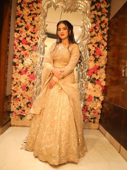 The full look against a floral backdrop. This golden lehenga is perfect for a grand engagement or reception party.