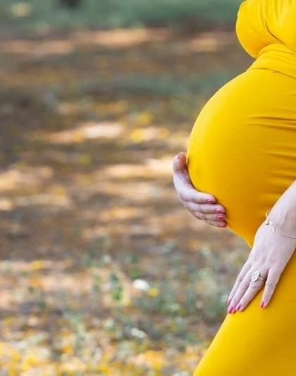 A close-up shot focusing on the hands cradling the baby bump. This intimate detail captures the deep connection between a mother and her unborn child.