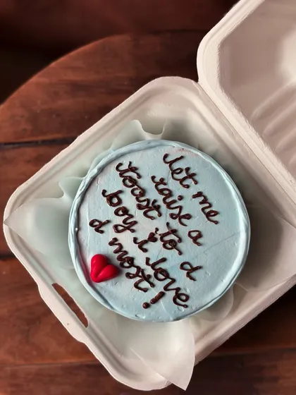 Another view of the "toast to a boy" bento cake, showing the clean lettering and simple design.