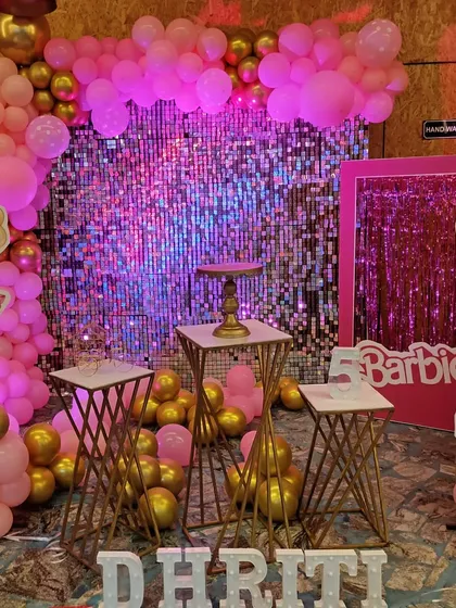 Another view of the glamorous Barbie party, showing the full effect of the pink sequin wall, character cutouts, and balloon decorations.