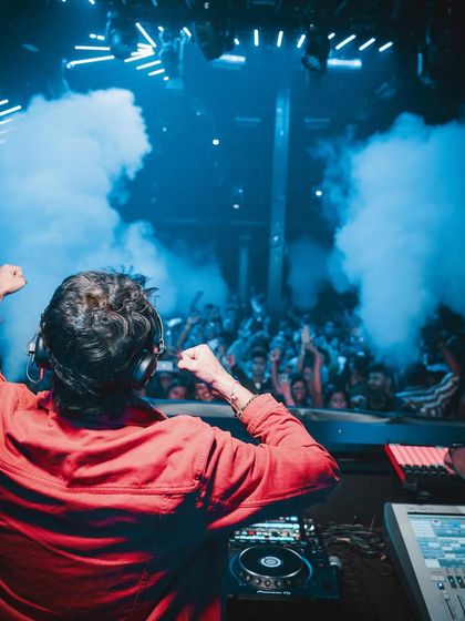 From behind, with both fists in the air, feeling the energy of the Goa crowd.