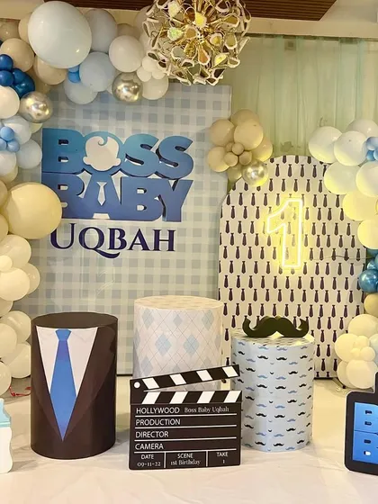 It's all business for Boss Baby Uqbah's first birthday. This fun theme included a city-skyline-inspired backdrop, character cutouts, and props like a director's clapperboard and a briefcase to complete the look.