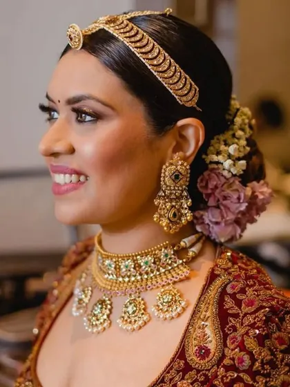A close-up of a bride's floral bun, showing the delicate arrangement of flowers. This hairstyle adds a touch of romance and freshness to the bridal look.