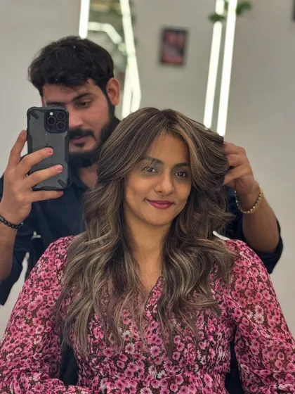 A client selfie during her Ash Blonde transformation. The cool, soft-toned highlights add elegance and trendiness to her long hair.