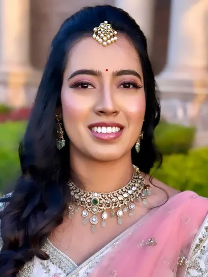 This is the beautiful Keerthi, glowing for her reception. I aimed for a fresh and luminous party makeup look, with soft pink tones on the eyes and lips to match her elegant lehenga, ensuring she looked and felt amazing all evening.