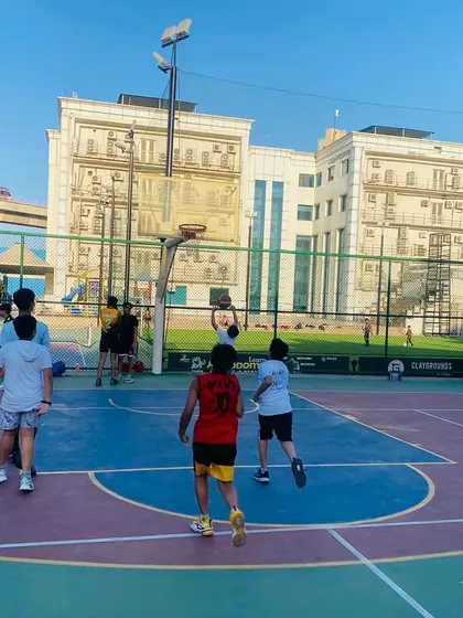 A player takes a shot with the metro and city buildings in the background, capturing our urban court vibe.