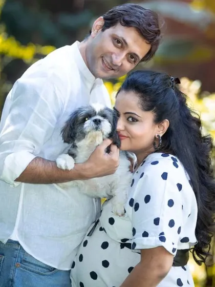 A beautiful family portrait including their beloved pet. This photo shows the couple's love for each other and their furry friend, who is waiting to become a big brother.