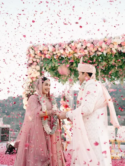 The perfect varmala shot, with the couple framed by a floral arch and a shower of petals. It’s a moment of pure, unscripted happiness.