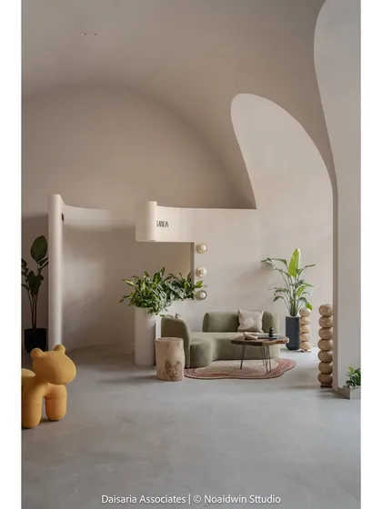 A minimalist composition showing the waiting area with its clean lines, organic forms, and the playful yellow bear-shaped seat.