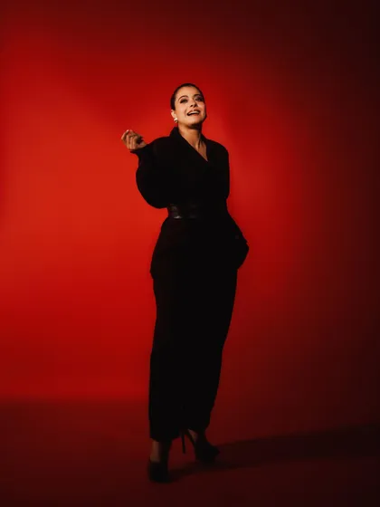 A full-length shot capturing a moment of laughter, showing the playful side of this otherwise dramatic look.