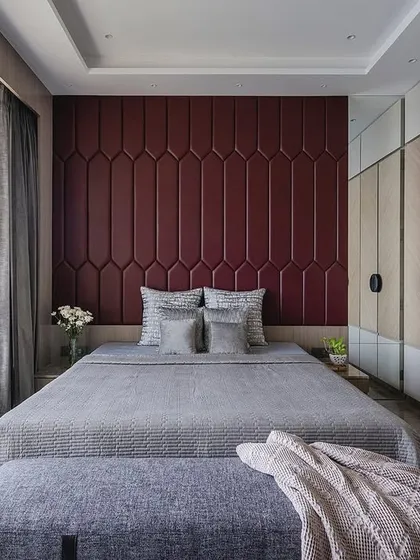 A full view of the bedroom with the bold red headboard, showcasing how it anchors the room. The large window provides plenty of light and a view of the city.