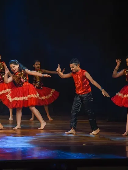 A group of young dancers executes a synchronized move, highlighting the teamwork and discipline we foster. Their coordinated outfits and confident poses make for a polished stage presentation.