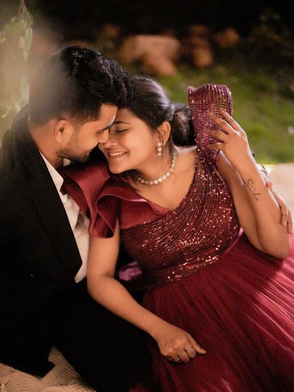 An intimate, romantic moment captured during a night shoot. The bride-to-be is wearing a sparkling red gown that catches the light beautifully.