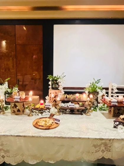 Another view of the elaborate food spread for a Diwali cards party. The combination of different heights, textures, and lighting creates a visually stunning focal point.