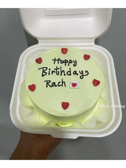 A light green bento cake with a simple 'Happy Birthday Rach' message, decorated with red hearts for a pop of color.