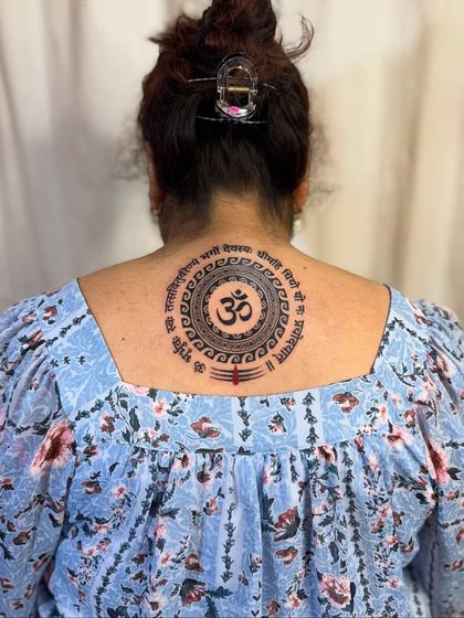 A full shot of the client wearing her new Om and Gayatri Mantra back tattoo.