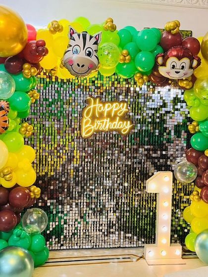 This is a duplicate of ID 100. A jungle animal theme with a glamorous twist. This setup features a gold shimmer wall, a neon sign, and a colorful balloon garland with animal head foil balloons.