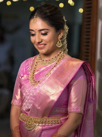 Heritage meets finesse with this classic South Indian bridal look for Lithika. We chose a soft, glowing makeup style to complement her beautiful Kanjeevaram saree and temple jewelry. Her hair was styled in a traditional braid adorned with fragrant mallige flowers, completing a look of timeless elegance.