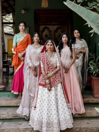 The bride poses with her bridesmaids, a beautiful portrait of friendship and celebration.