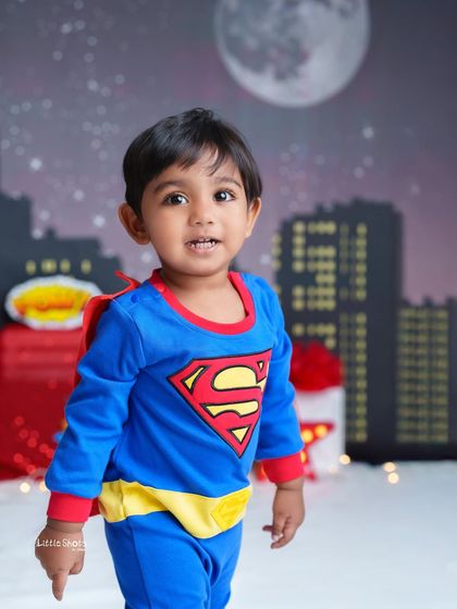 Our little Superman is ready for action! This photo captures his sweet and heroic side against a starry night and city skyline.