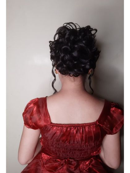 A voluminous and messy curly updo. This hairstyle is perfect for evening gowns and cocktail dresses, adding a touch of romantic sophistication to the overall look.