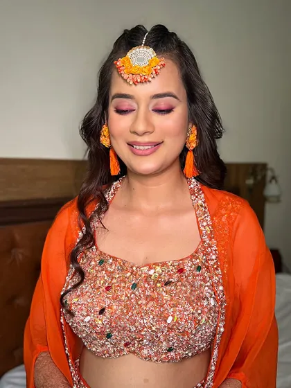 A close-up of this vibrant Haldi look. The pink and orange eyeshadow complements her outfit beautifully, creating a look that is both traditional and fun.