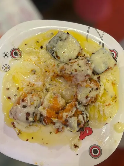 A plate of our Turkish Chicken, showcasing the creamy sauce and a generous sprinkle of herbs and spices. It's as delicious as it looks.