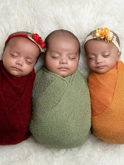 Another beautiful arrangement of the triplet girls, each with their own little floral accessory, showcasing their individual yet connected presence.
