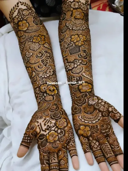 Hiba's mehndi, with the groom's name 'Shehbaz' beautifully written on her palm amidst a garden of henna flowers.