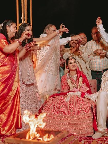 Family and friends bless the couple as they sit by the sacred fire during their wedding ceremony.
