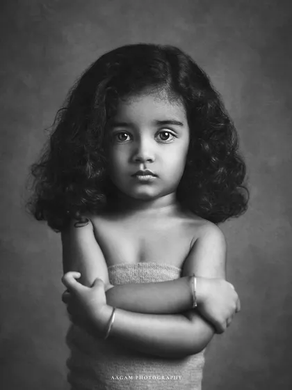 The black and white version of this stunning child's portrait. The monochrome tones enhance her expressive eyes and the beautiful curls of her hair, creating a powerful and soulful image.