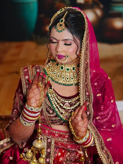 This student's work features a classic bridal look with a maroon velvet lehenga and contrasting green jewelry. We teach color theory to help students make bold, beautiful choices.