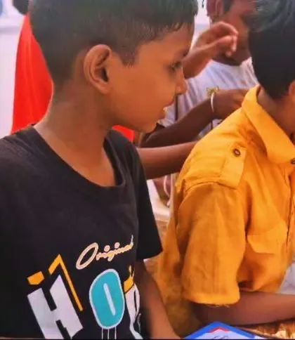Two boys carefully look through the books from our outreach initiative. Even without a permanent library, these moments of access to stories can spark a lifelong love for reading.