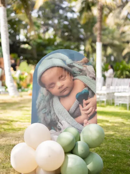 A sweet photo cutout for Shourya's safari-themed first birthday. The sleeping baby picture, combined with a balloon base, adds a touch of 'aww' to the jungle adventure decor.