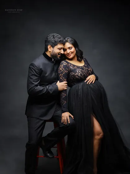 An intimate seated portrait of the couple. The black gown and suit create a formal, elegant look, while the pose feels warm and connected.