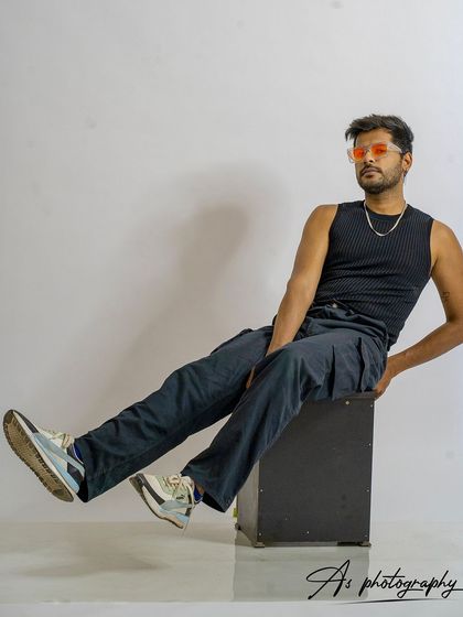 A full-body seated pose in the studio. This demonstrates how a model can use their entire body to create an interesting shape even while sitting.