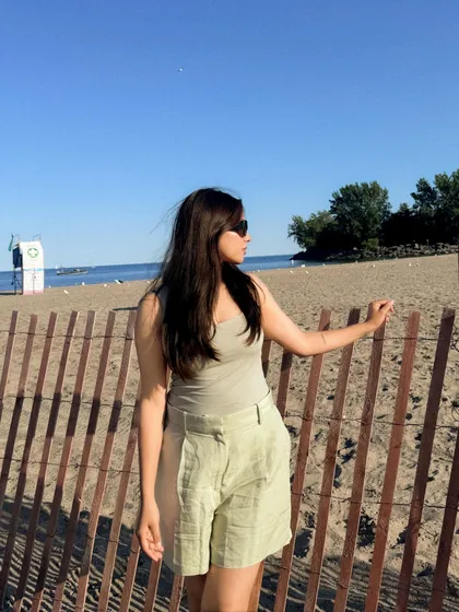 A relaxed pose against the beach fence, capturing the easygoing vibe of a summer day.
