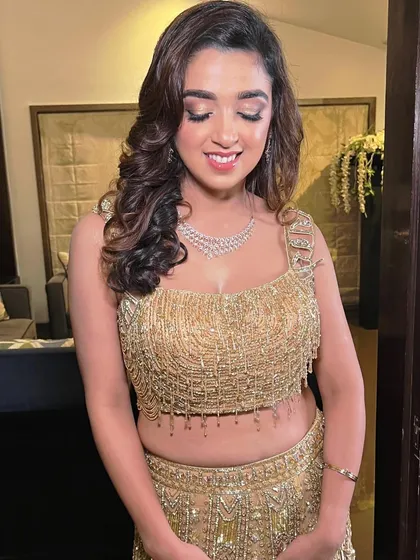 Sangeet ready with a beautiful smile. This bride is glowing in her golden beaded top, with soft, shimmery makeup to match.