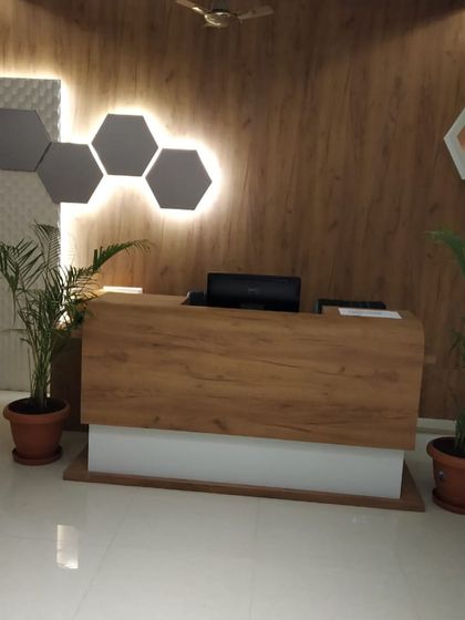 The reception desk at the clinic is clean and minimalist, with a wood-grain finish that complements the wall treatments.