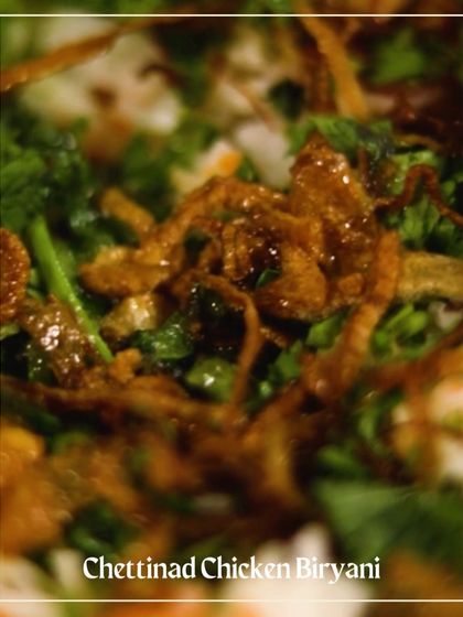 A close-up of the fragrant Chettinad Chicken Biryani, layered with herbs and fried onions.