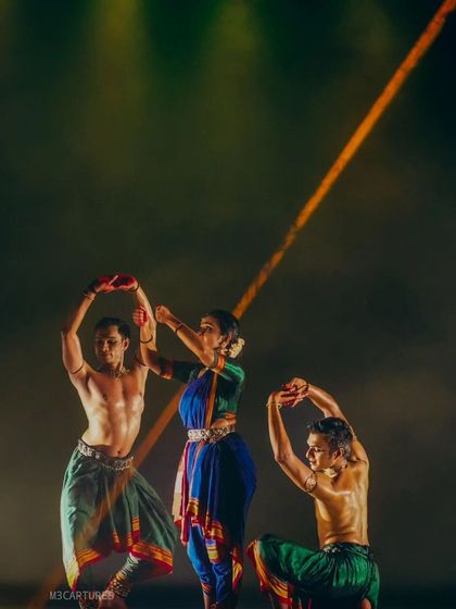 A moment from 'Nagamandala' where the dancers are framed by a beam of light. This shows the careful integration of choreography and lighting design in our productions.