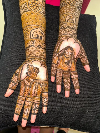 A finished design featuring portraits of the bride and groom on the palms. It’s a beautiful way to tell their story.