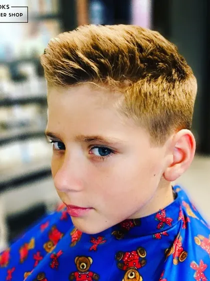 A side profile of this cool, textured haircut. This angle highlights the clean lines around the ear and the expertly blended length on top, creating a sharp silhouette.