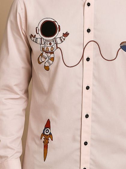 This shot provides another angle on the detailed embroidery, highlighting the clean finish and quality of the threadwork on the light pink cotton fabric.