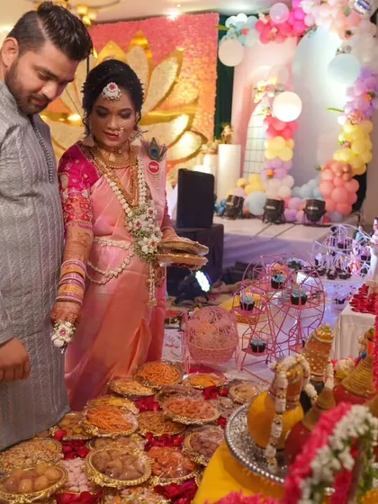 The parents-to-be at their `dohale jevan`, looking at the extensive food table filled with traditional snacks and modern desserts.