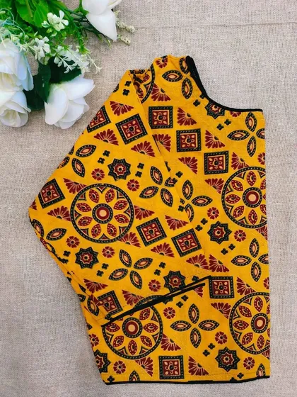 A mustard yellow cotton boatneck blouse with a classic mandala-style print.