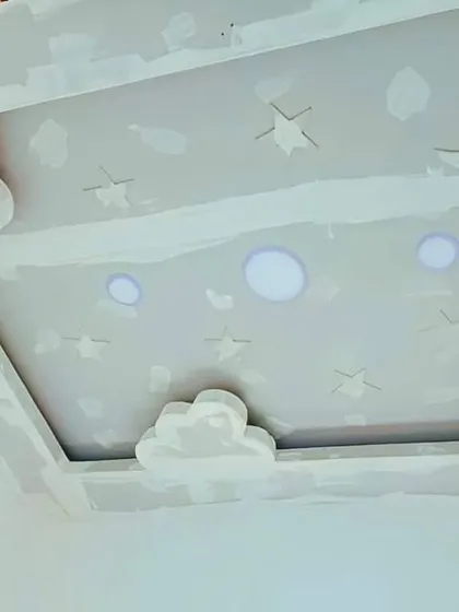 A complete sky-themed ceiling in progress, with clouds, stars, and a moon. This unpainted gypsum design shows the full scope of a creative project for a child's room.